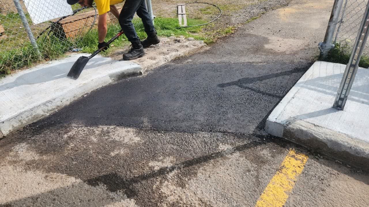 Équipe PAVEX en train de réparer une section d'asphalte endommagée sur un stationnement